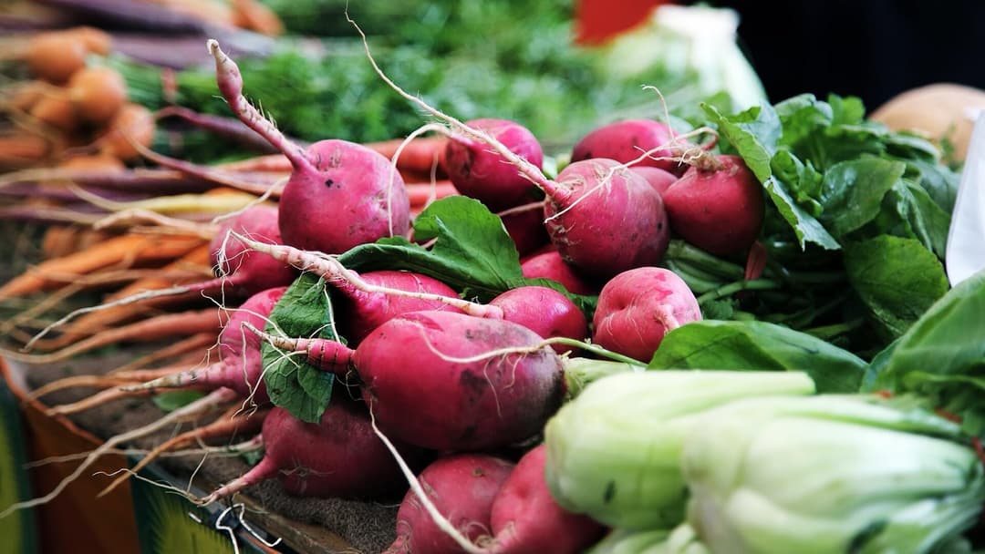 Fresh vegetables piled on a market stall